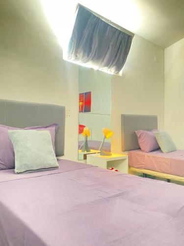a bedroom with two beds with purple sheets at Best Rooms- Quarto 2 Plateau in Praia