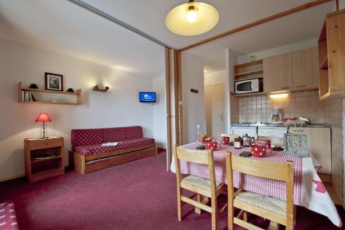une cuisine et une salle à manger avec une table et un canapé dans l'établissement Résidence La Marmottane, à Aime