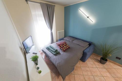 Schlafzimmer mit einem Bett mit blauer Wand in der Unterkunft Centro di Aosta - Bilocale grazioso e silenzioso in Aosta