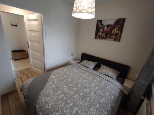 a bedroom with a bed and a chandelier at ***Casablanca Apartament*** - 40m² ✓ in Rybnik
