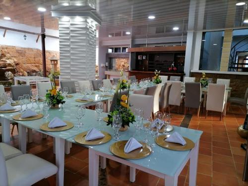 a dining room with white tables and white chairs at Hotel Mansión Barichara in Barichara