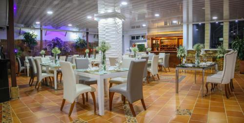a dining room with white tables and chairs at Hotel Mansión Barichara in Barichara