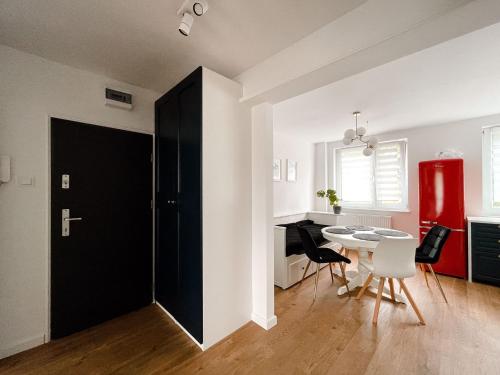 a room with a black door and a table and chairs at Apartament Kętrzyn in Kętrzyn