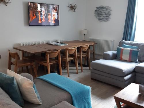 Seaclusion في Saint Monance: غرفة معيشة مع طاولة خشبية وأريكة