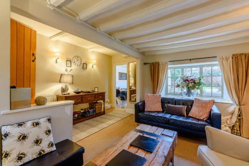 a living room with a couch and a table at Orchard Cottage, Broadway in Broadway