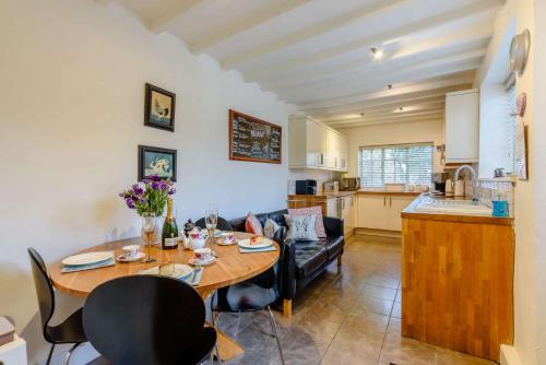 a kitchen and living room with a table and chairs at Orchard Cottage, Broadway in Broadway