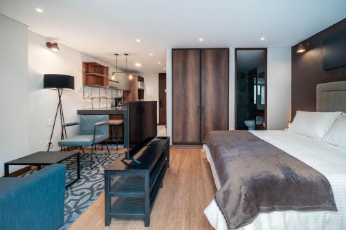 a bedroom with a large bed and a kitchen at Gestión Hotelera - Morph Candelaria in Bogotá