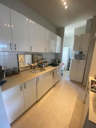 a kitchen with white cabinets and a sink at charming tlv two bedroom in Tel Aviv