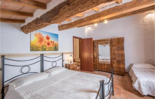 a bedroom with a bed and a painting on the wall at Gorgeous Home In Montalcino With Kitchen in Montalcino