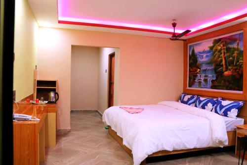 a bedroom with a large bed with a purple light at Hotel National Park Sauraha- Homely Stay and Peaceful Location with Jungle Safari arrangements in Sauraha