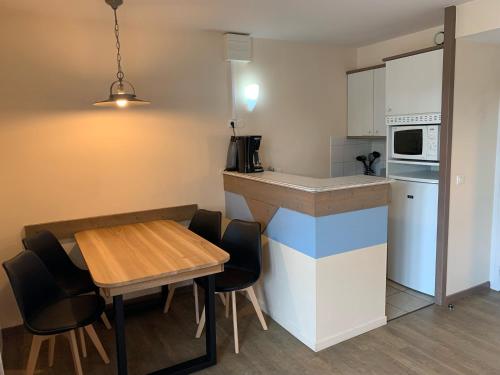 - une petite cuisine avec une table et un comptoir dans l'établissement Appartement Belle Dune, à Fort-Mahon-Plage
