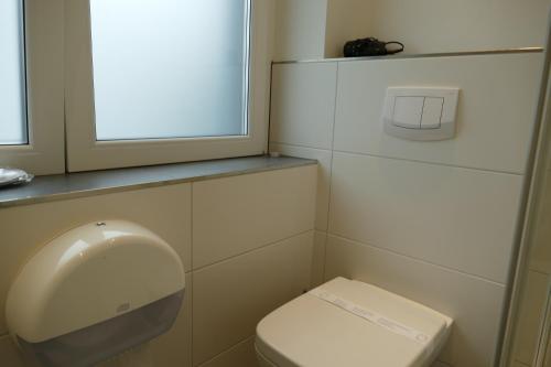 a bathroom with a toilet and a window at Pension Sölde UG in Dortmund
