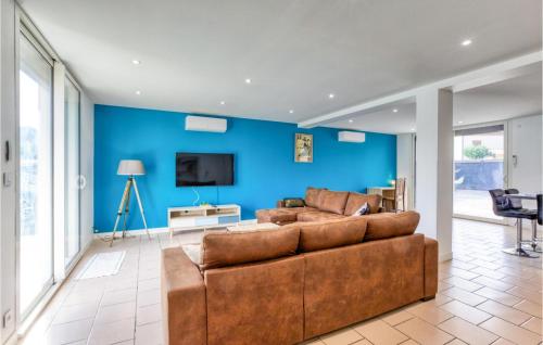 - un salon avec un canapé brun et un mur bleu dans l'établissement Beautiful Home In Albi, à Albi