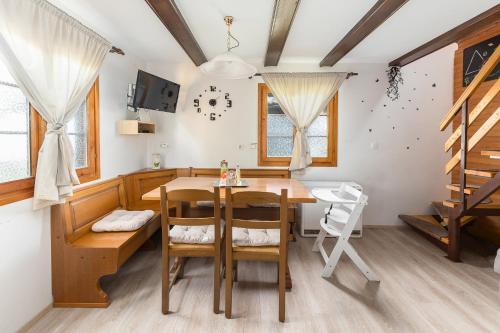 a dining room with a wooden table and chairs at Brunarica Primas Čatež in Brežice