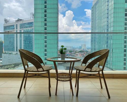 uma mesa e 2 cadeiras numa varanda com vista em KSL Desplanade By Antlerzone em Johor Bahru