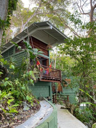 a green house with a balcony on top of it at Casa Galú - Capurganá in Capurganá