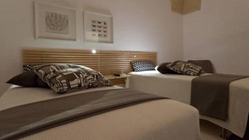 a room with two beds and a desk in a room at Rescio's Rooms in Cavallino di Lecce