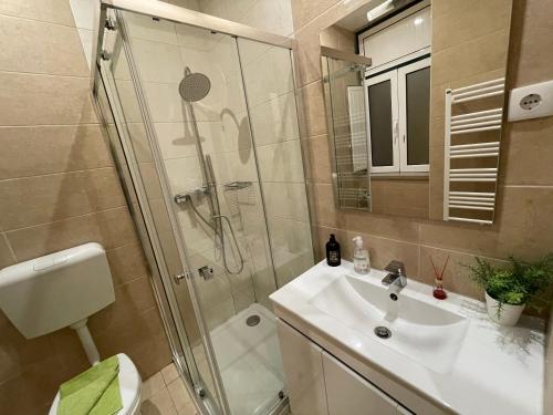 a bathroom with a shower and a sink and a mirror at Alojamento Porta10 in Sertã