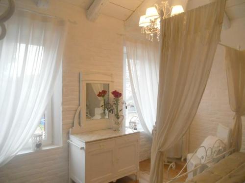 una habitación con espejo y un tocador con flores. en Bed & Breakfast Canova, en Treviso