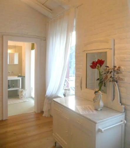 a white room with a vase of flowers on a counter at Bed & Breakfast Canova in Treviso