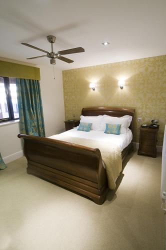 a bedroom with a large bed and a ceiling fan at Hall Farm Hotel And Restaurant in Ashby cum Fenby