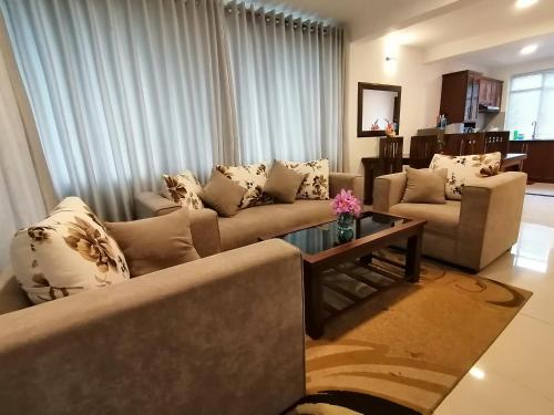 a living room with two couches and a table at Moon Plains Luxury Apartments in Nuwara Eliya