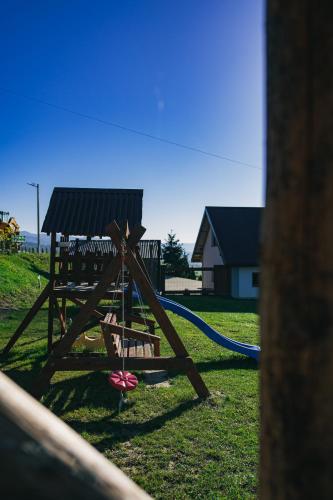 a playground with a slide in a yard at Słoneczny Domek in Grywałd