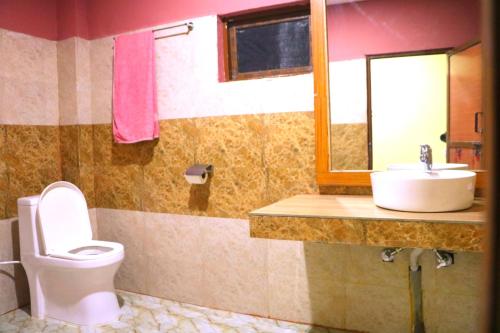 a bathroom with a toilet and a sink at Hotel National Park Sauraha- Homely Stay and Peaceful Location with Jungle Safari arrangements in Sauraha