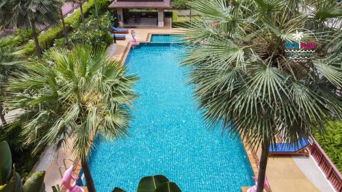 Patong Coco Apartment في شاطيء باتونغ: اطلالة علوية على مسبح به نخيل