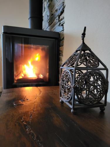 a candle holder sitting on a table in front of a fireplace at Villa Alva Guest House in Coja