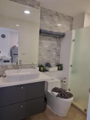 a bathroom with a sink and a toilet and a mirror at Patong Coco Apartment in Patong Beach