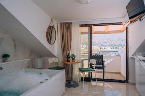 La salle de bains est pourvue d'une baignoire, d'une table et de chaises. dans l'établissement Villa Fortuna, à Ohrid