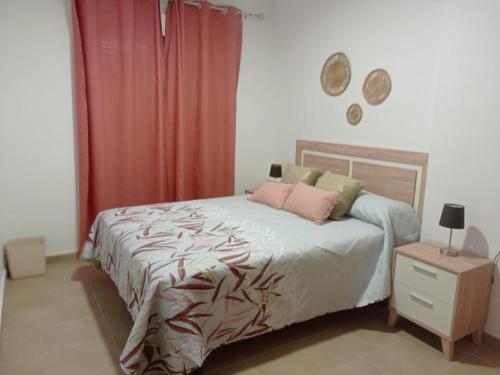 1 dormitorio con cama y cortina roja en El Barro Colorao, en Segura de León