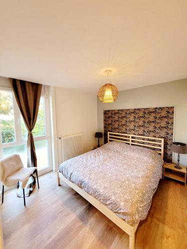 une chambre avec un lit et une chaise dans l'établissement Le Rocher du Lac, à Annecy