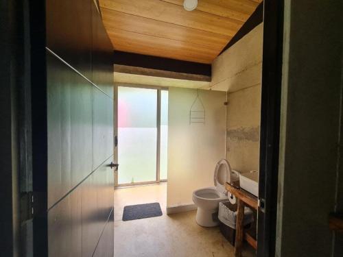 a bathroom with a toilet and a window at Eco Lung Hotel in Montezuma