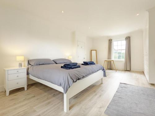 a white bedroom with a large bed and a window at The White House - Bordon in Bordon