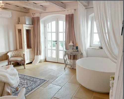 a bathroom with a large white tub in a room at Maison Bagatell Badacsony in Badacsonytomaj
