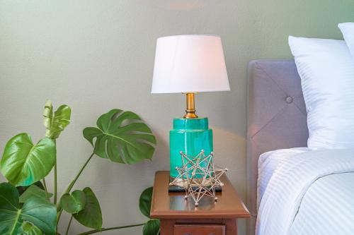 a green lamp on a table next to a bed at The Estate at Mt Dora in Mount Dora