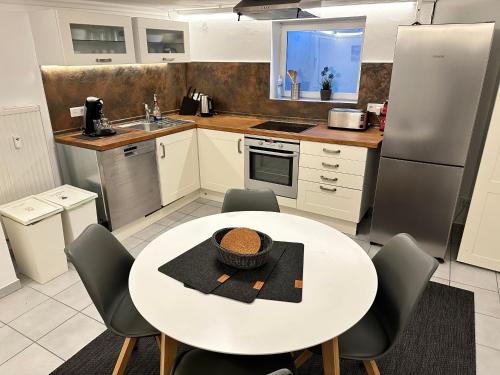 a kitchen with a white table and chairs and a white table at Modernes Apartment mit Terrasse und Highspeed Internet zwischen Aalen und Schwäbisch Gmünd in Göggingen