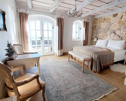 een slaapkamer met een bed, een tafel en een stoel bij Maison Bagatell Badacsony in Badacsonytomaj