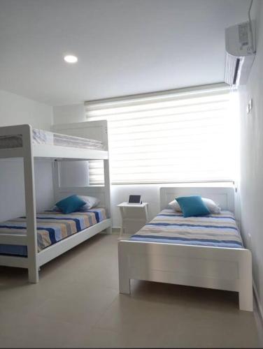 sypialnia z 2 łóżkami piętrowymi i oknem w obiekcie Edif. Deymar - Departamento frente al mar 9no piso w mieście Tonsupa