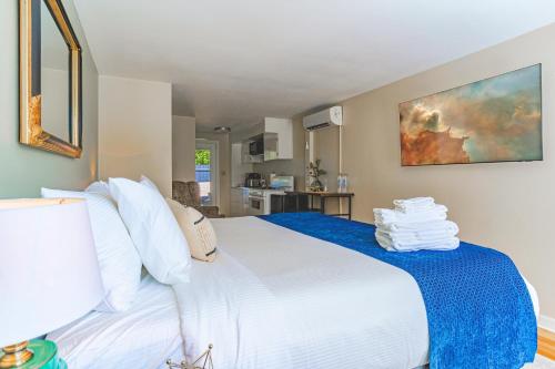 a bedroom with a large white bed with blue sheets at The Estate at Mt Dora in Mount Dora