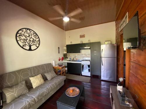 a living room with a couch and a kitchen at Casa Natural Madera in Brasilito