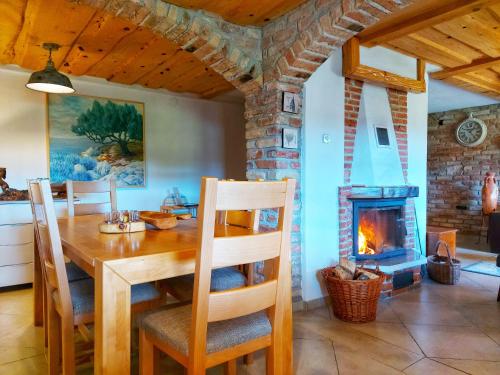 a dining room with a table and a fireplace at Peter's Pine Cottage in Korenica