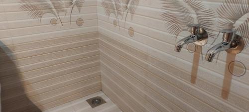 a corner of a bathroom with a shower with stripes at Marari Casa Almare in Mararikulam