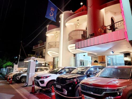 grupa samochodów zaparkowanych przed budynkiem w obiekcie Solitude, The Boutique Hotel w mieście Haldwani