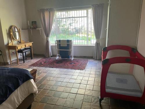 1 dormitorio con 2 camas, ventana y escritorio en HEELTEVREDE Self-Catering farmhouse, en Bloemfontein
