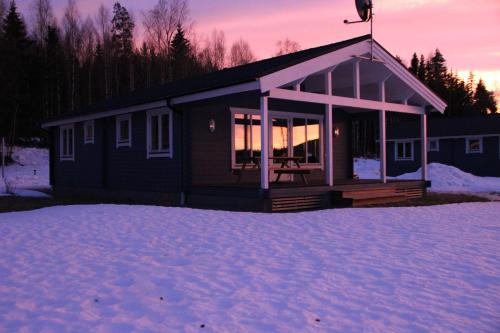 a small cabin in the snow in the sunset at Lakeview Houses Sweden in Falun