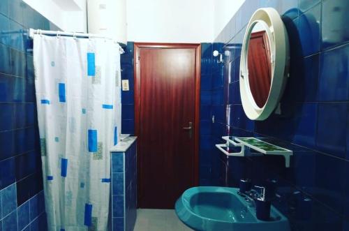 a blue bathroom with a shower and a sink at Il Quadrifoglio di Triveri in Bovalino Marina