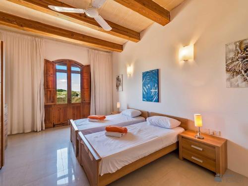 a bedroom with two beds and a window at The Arches Holiday Home in Kerċem